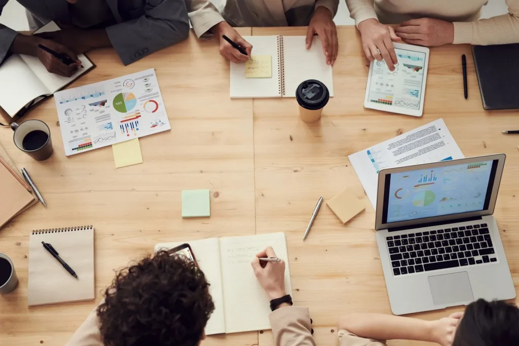 Business team reviewing charts and plans around a table