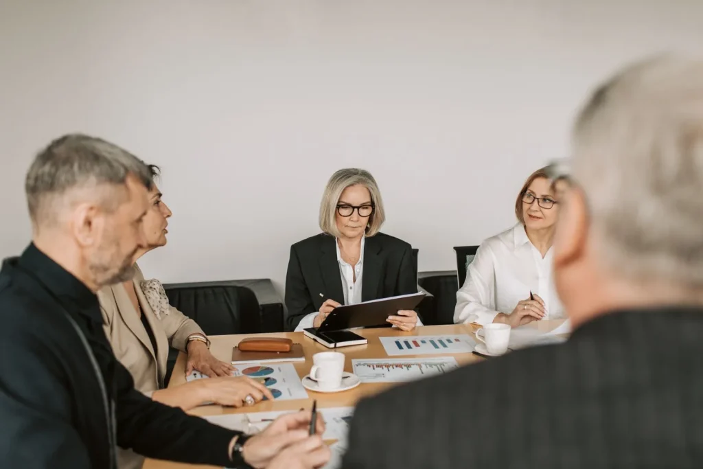 Professionals reviewing business plans around a meeting table