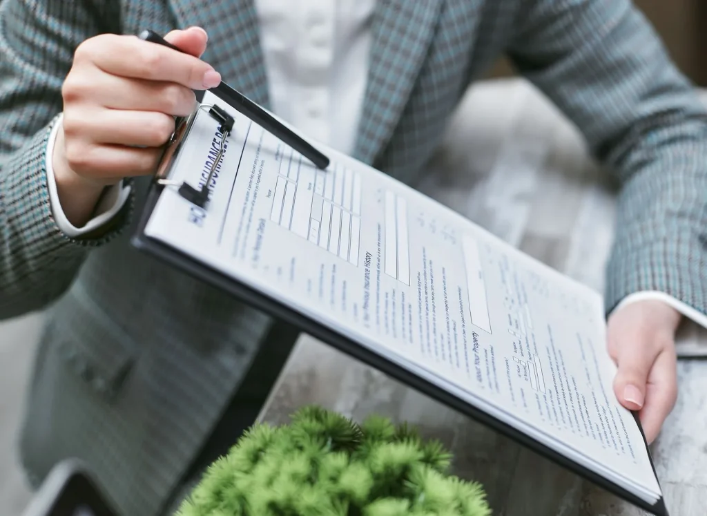 Professional reviewing insurance paperwork on a clipboard