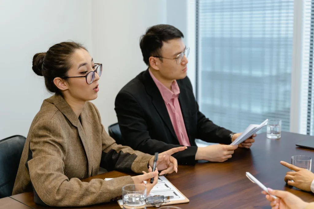 Two professionals discussing documents during a business meeting